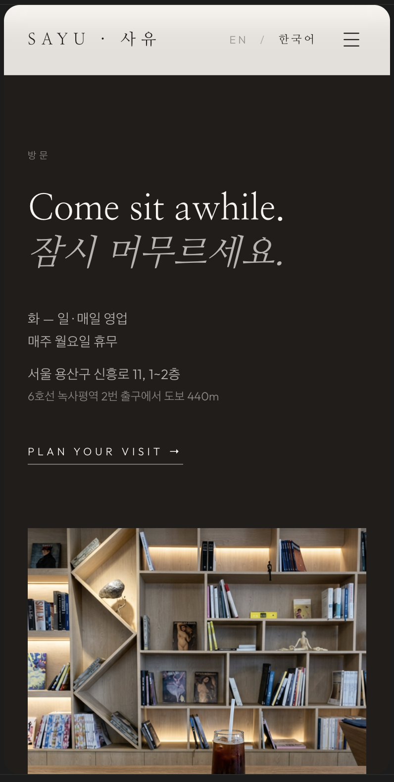 Visit — hours, address and transit, with a quiet hero line in both languages.